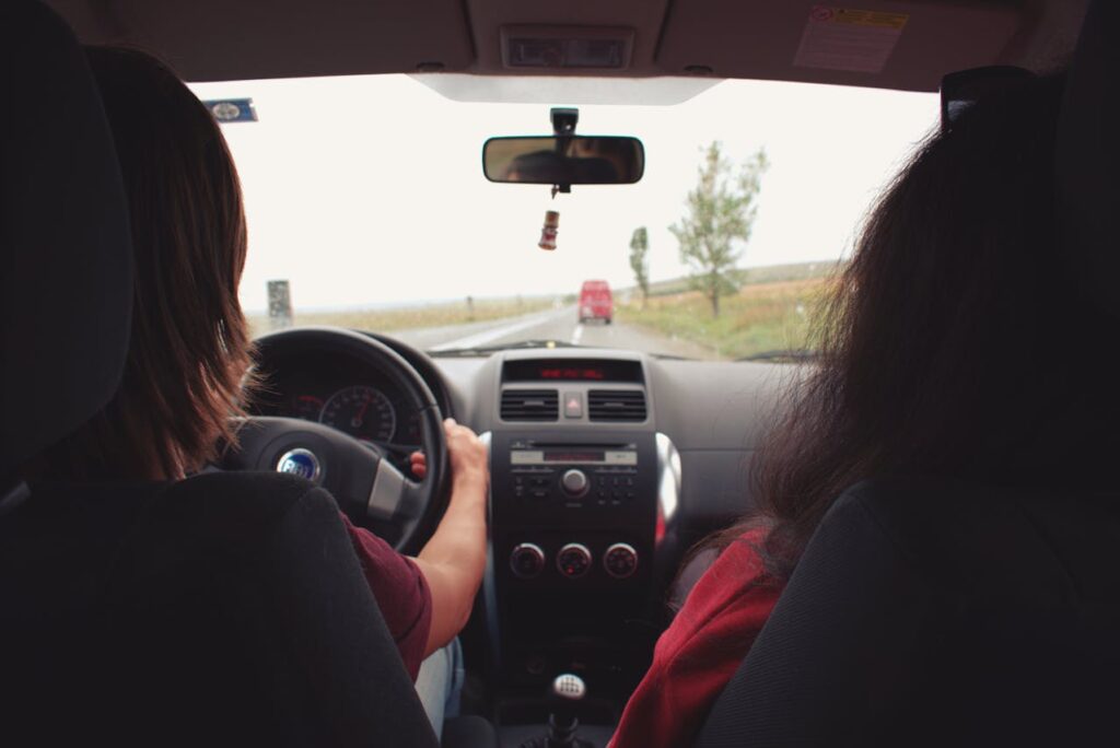 Driver and passenger traveling on an open highway during a road trip, highlighting practical travel safety tips for staying aware while on the road.