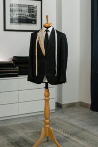 Tailored black suit jacket displayed on a mannequin showing craftsmanship and structure for what to look for when buying a custom suit.