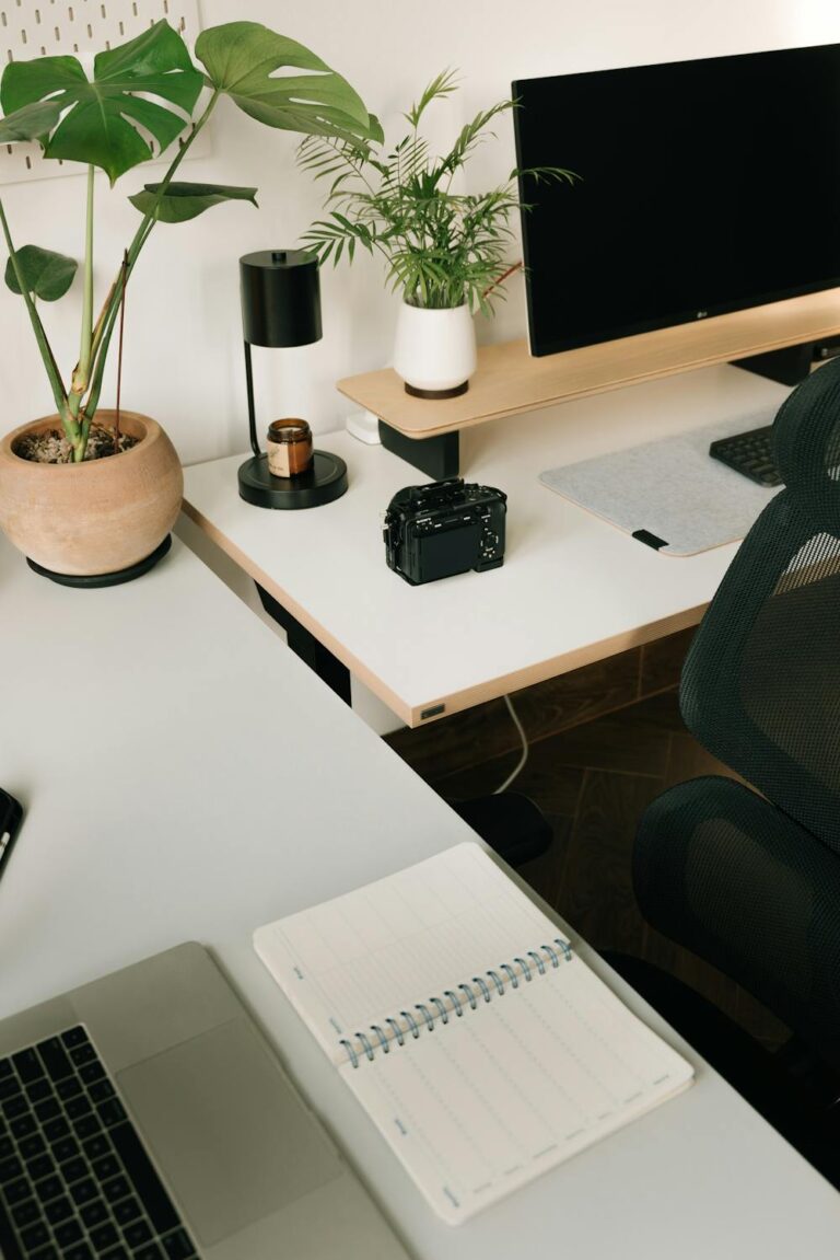 Cozy desk setup with plants, notebook, and modern workspace decor