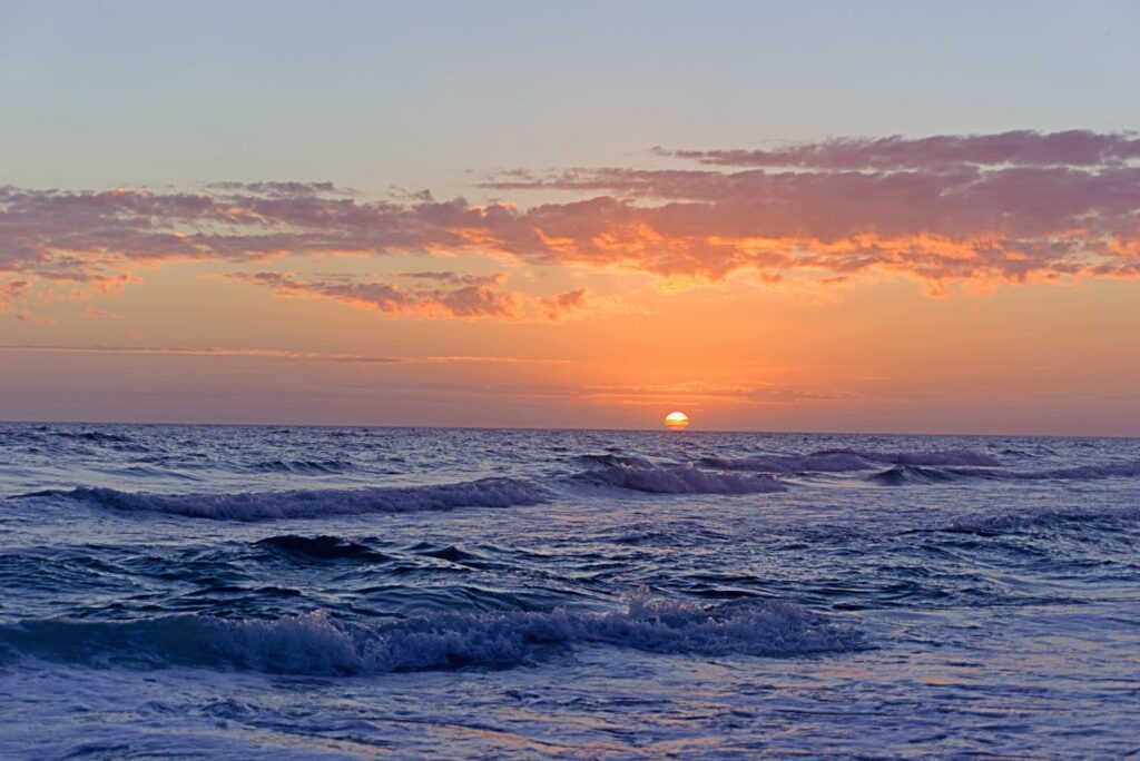 Colorful ocean sunset with waves rolling onto a peaceful Florida beach