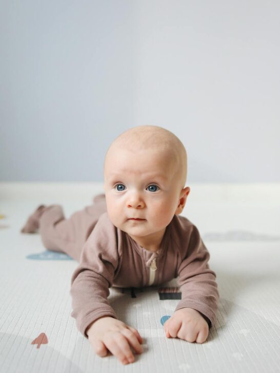 Baby lying on tummy during playtime, representing gentle care with natural baby products