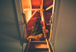 View from ladder into attic with stored seasonal items and lighting for easy retrieval