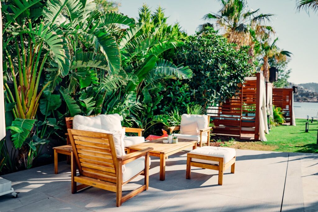 Backyard seating area with wooden furniture and lush greenery creating a peaceful and private outdoor relaxation space