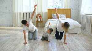 family-friendly exercises with parents and child doing a simple stretch together at home