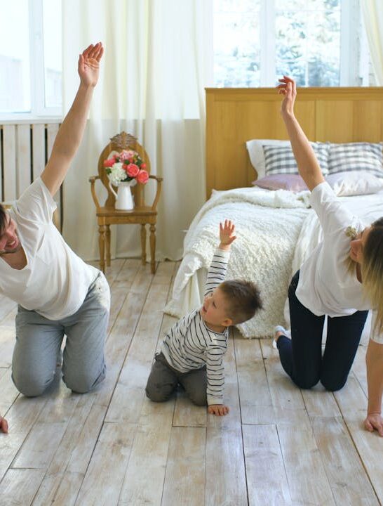 family-friendly exercises with parents and child doing a simple stretch together at home