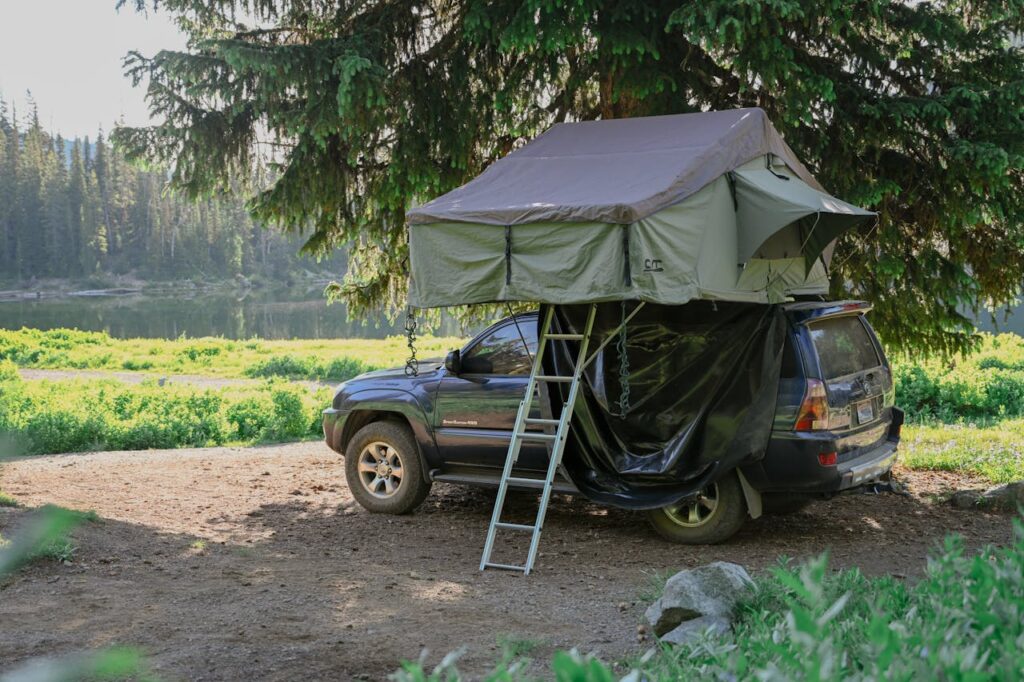 SUV with rooftop tent set up under the trees showing a practical car camping setup for weekend adventures