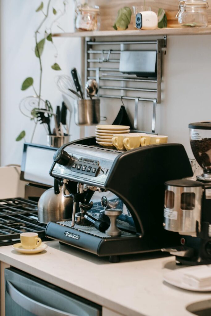 Coffee bar ideas for home featuring espresso machine setup with mugs and accessories on kitchen counter