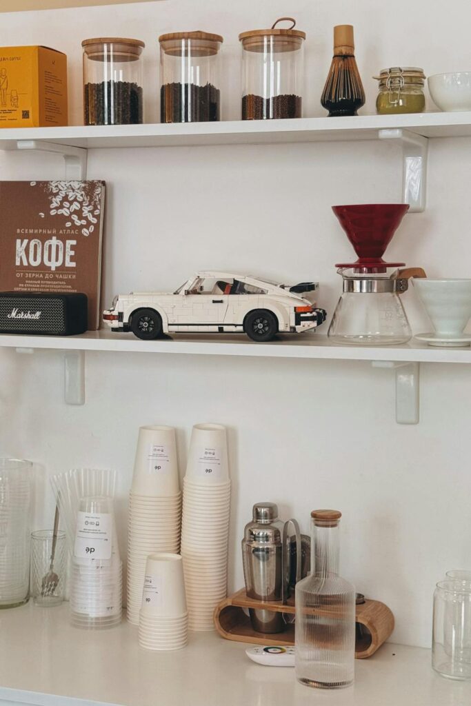 Coffee bar ideas for home with organized shelves, coffee beans in jars, pour-over setup, and stacked cups
