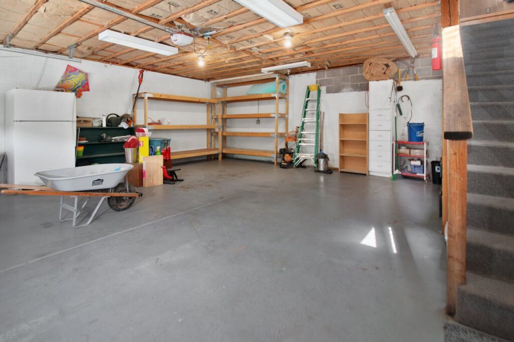 Garage organization hacks showing a clean, open garage with shelving and tools neatly arranged