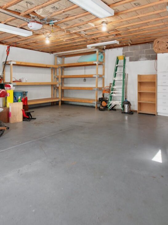 Garage organization hacks showing a clean, open garage with shelving and tools neatly arranged