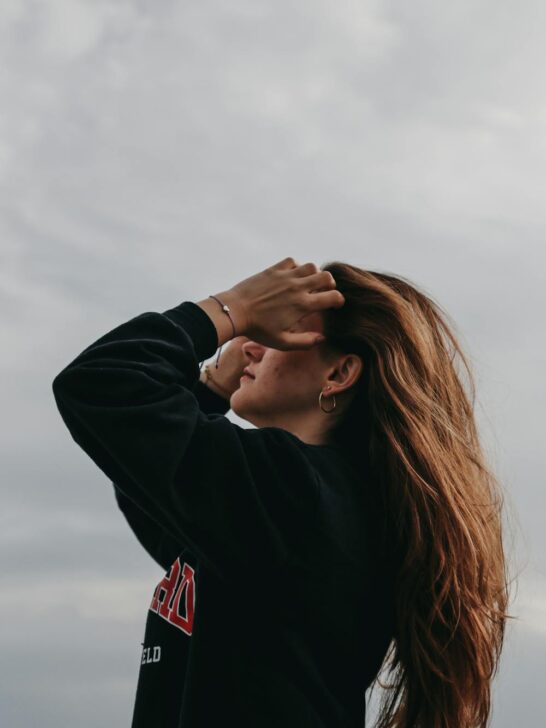 Woman flipping her hair back outdoors to naturally boost volume and movement