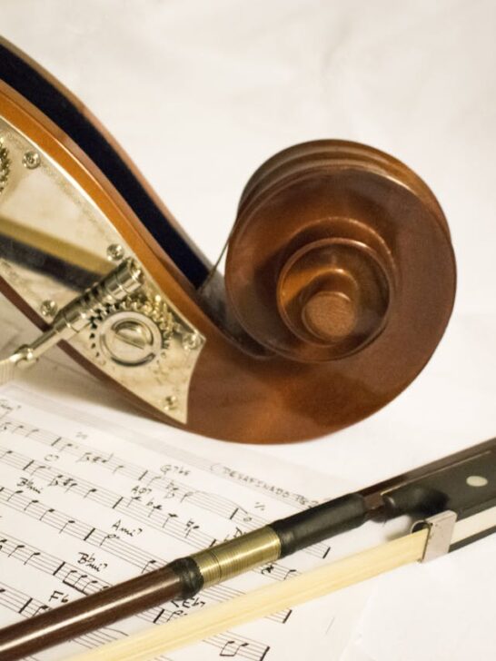 violin resting on sheet music with bow, showing beginner music practice setup