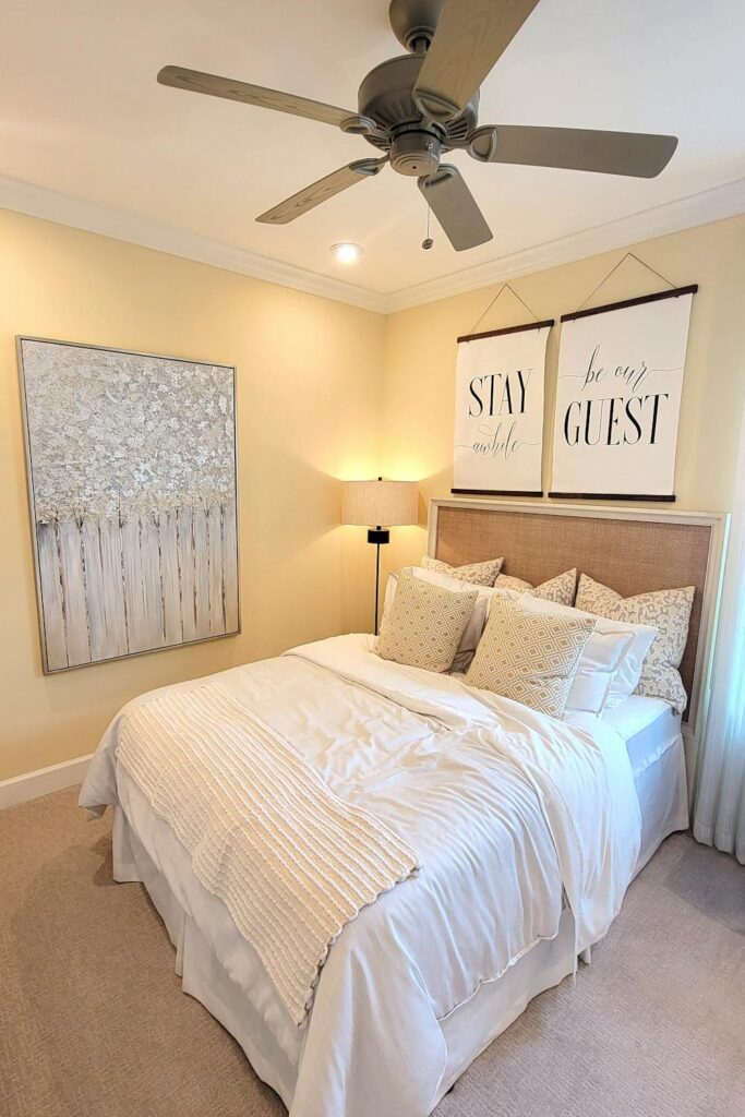 Cozy guest bedroom setup with layered bedding, wall decor, and soft lighting for a welcoming feel