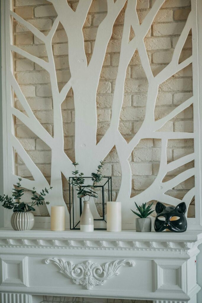 Mantel decor ideas featuring a white fireplace mantel styled with greenery, candles, and modern decorative accents