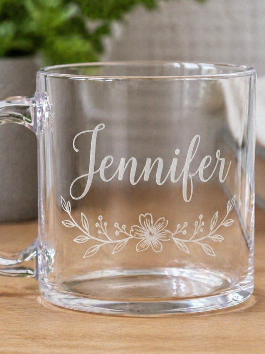Clear acrylic mug engraved with the name Jennifer and a delicate floral design on a wooden surface