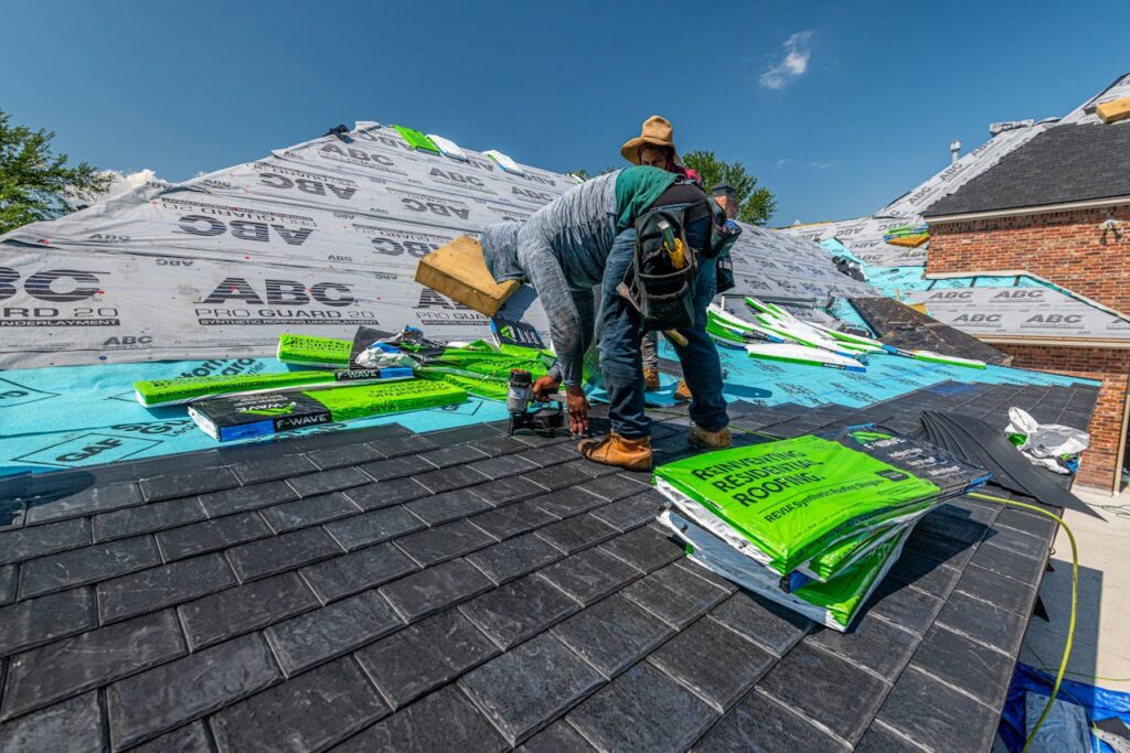 Roofing contractor installing shingles and underlayment during residential roof replacement project