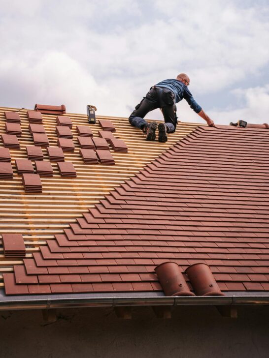 Proactive roofing care with a contractor installing new roof tiles on a residential home