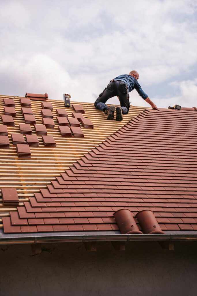 Proactive roofing care with a contractor installing new roof tiles on a residential home