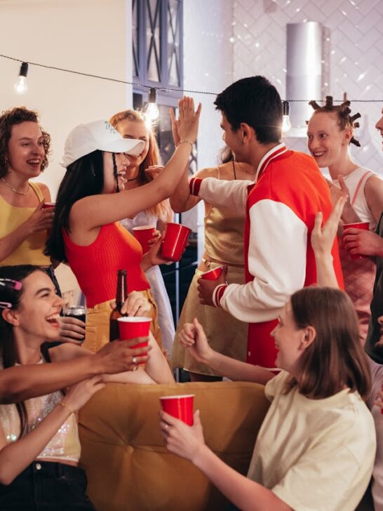 Group of friends celebrating indoors with drinks, laughter, and a lively party vibe