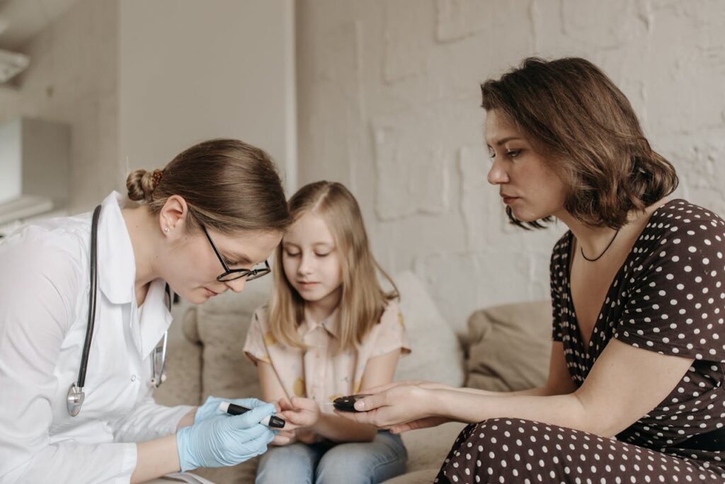 Doctor checking a child&rsquo;s blood sugar levels during an at-home visit with a parent, highlighting factors that affect home health care insurance cost.