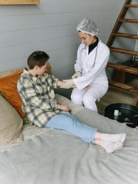 Nurse providing in-home medical care to a patient while discussing home health care insurance cost and long-term care support options.