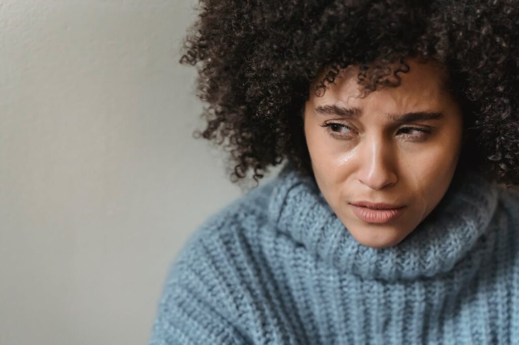 Woman looking stressed and fatigued, showing signs of burnout and mental exhaustion