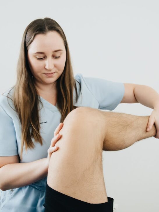 Physical therapist examining a patient&rsquo;s knee to show how to relieve knee pain and improve joint mobility