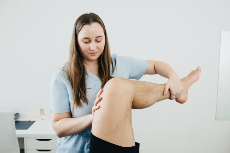 Physical therapist examining a patient&rsquo;s knee to show how to relieve knee pain and improve joint mobility