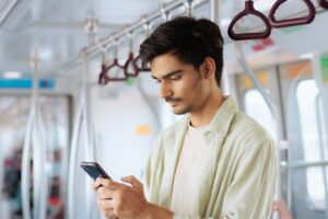 A person using a smartphone to access GPS tracking and location services while traveling on public transportation.
