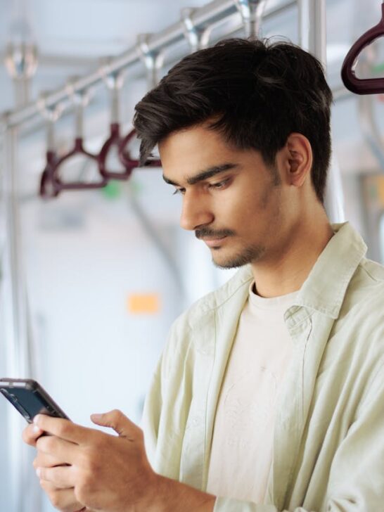 A person using a smartphone to access GPS tracking and location services while traveling on public transportation.