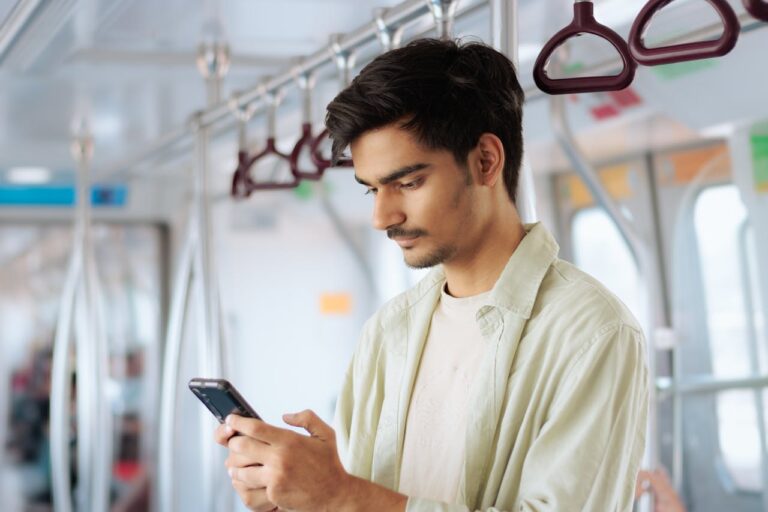 A person using a smartphone to access GPS tracking and location services while traveling on public transportation.