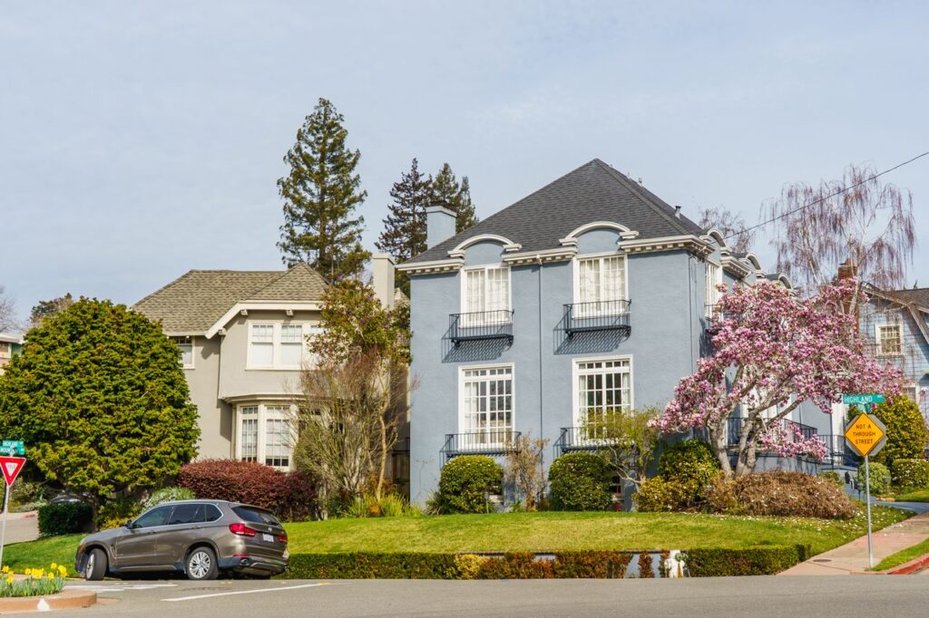 Well-maintained suburban homes with trimmed lawns, flowering trees, and attractive landscaping that enhance curb appeal and property value.