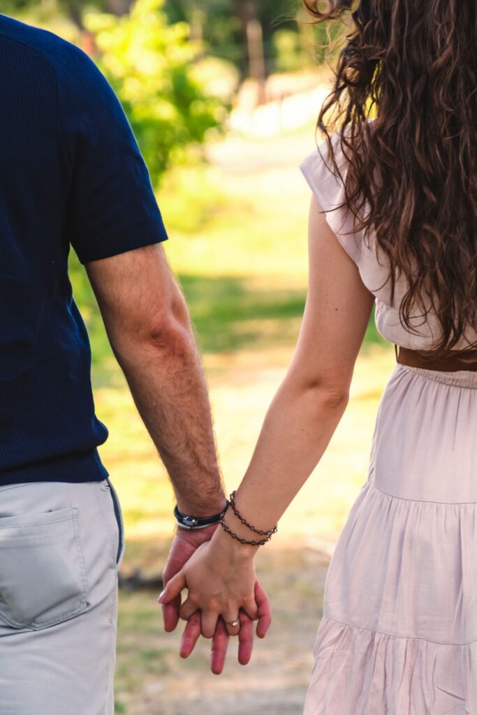 Couple holding hands while walking together, celebrating everyday relationship milestones and lasting commitment.