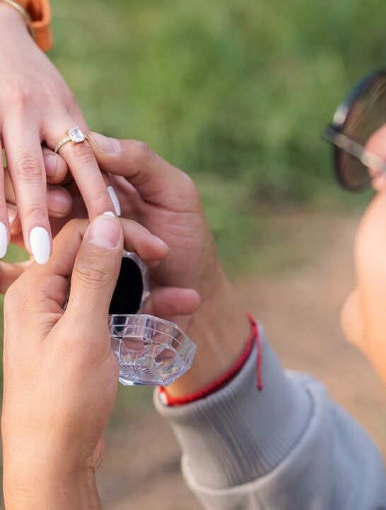 Man proposing with an engagement ring during a romantic outdoor proposal.
