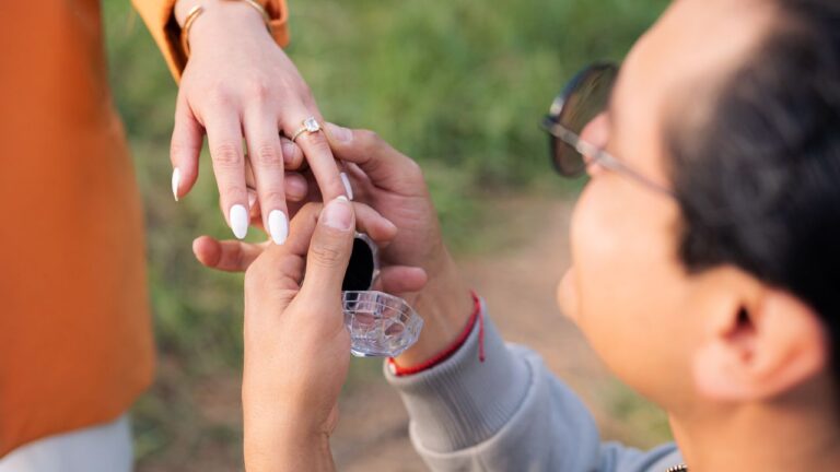 Man proposing with an engagement ring during a romantic outdoor proposal.