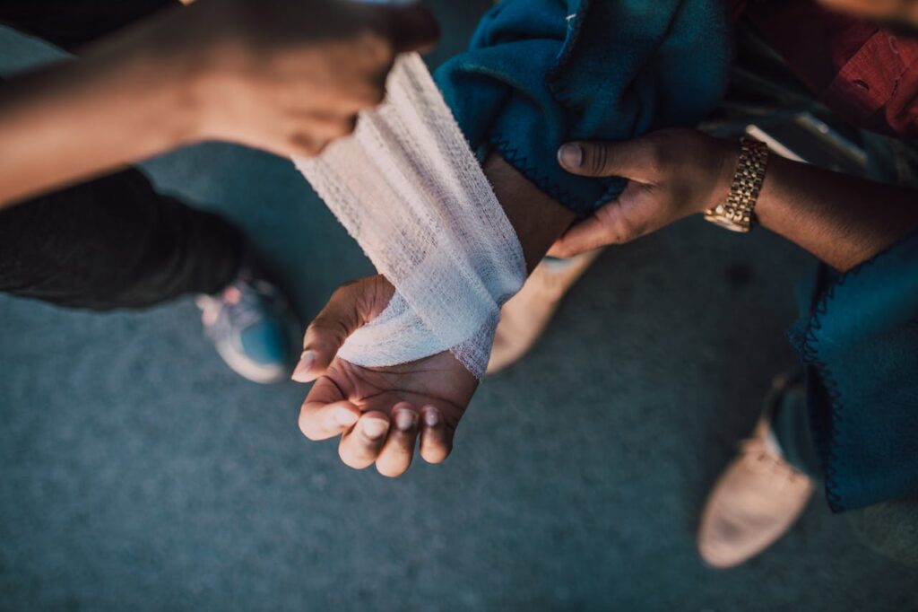 Medical professional wrapping an injured wrist with a bandage following an accident-related injury.