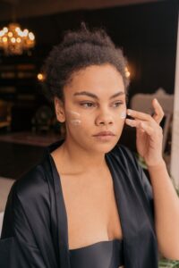 Person applying skincare cream to the face as part of a daily routine designed to improve hydration, elasticity, and skin firmness over time.