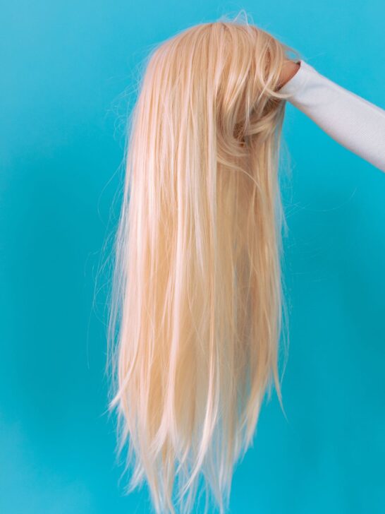 How to make a lace front wig look natural with a long, straight blonde lace front wig displayed against a blue background.