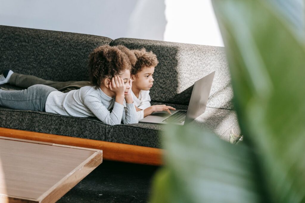 Children learning how to protect personal information online while using a laptop at home.