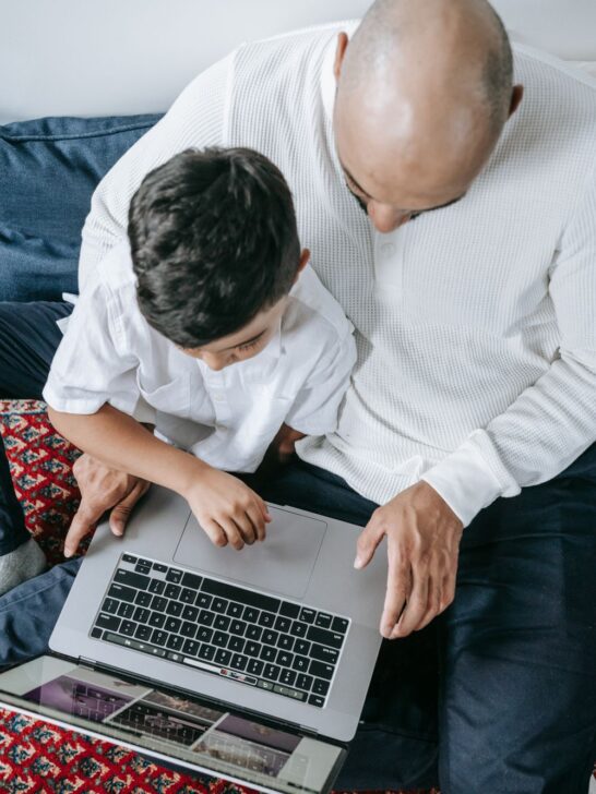 Parent helping a child use a laptop safely while teaching good online privacy habits.