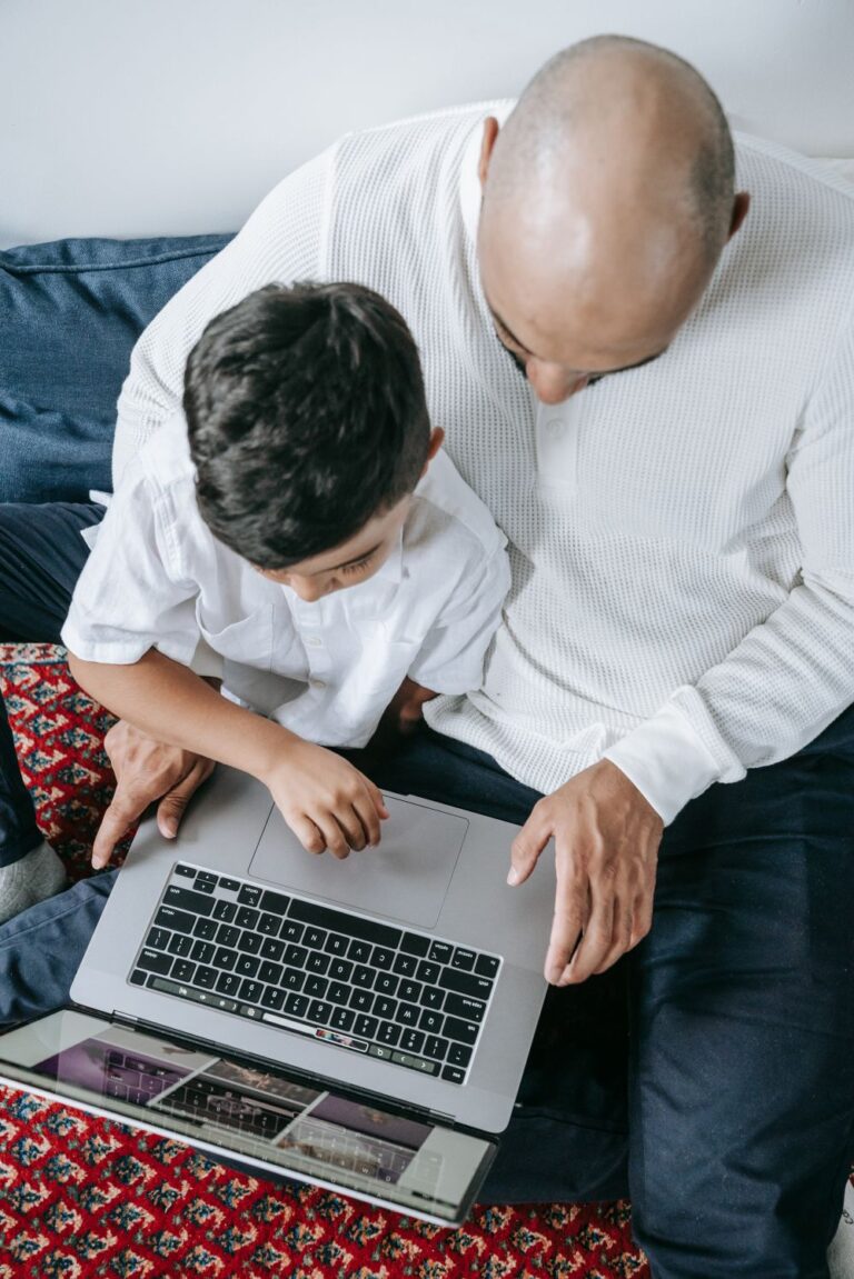 Parent helping a child use a laptop safely while teaching good online privacy habits.