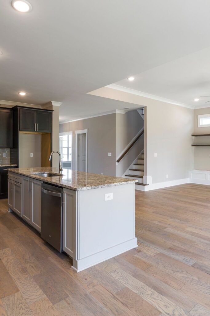 Bright open-concept interior of a new home with a modern kitchen island, hardwood floors, and updated finishes.