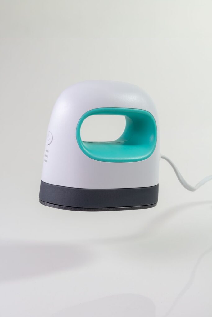 Mini heat press machine used for customizing personalized crossbody bags with heat transfer vinyl designs