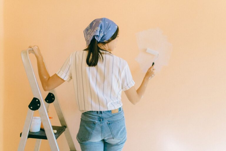 Homeowner painting an interior wall during a DIY project while preparing to sell your house fast without major renovations.