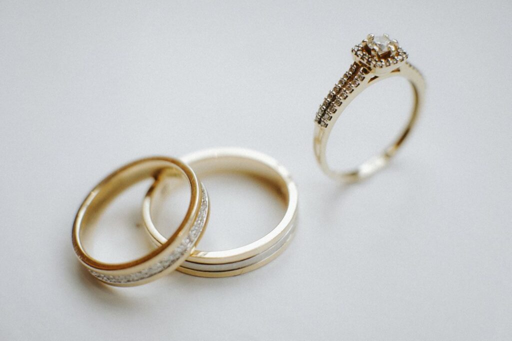 Anniversary ring with matching gold wedding bands displayed on a white surface.