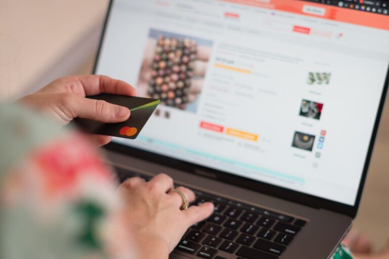 Laptop displaying an online shopping page with colorful shopping bags, representing how to buy home products online with confidence.