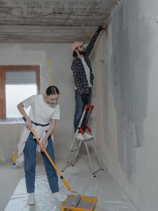 Couple completing family-friendly home projects by painting and renovating a room together.