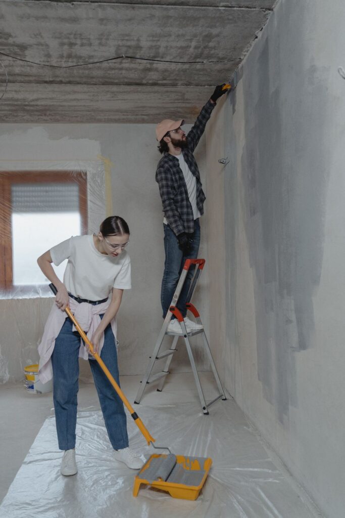Couple completing family-friendly home projects by painting and renovating a room together.