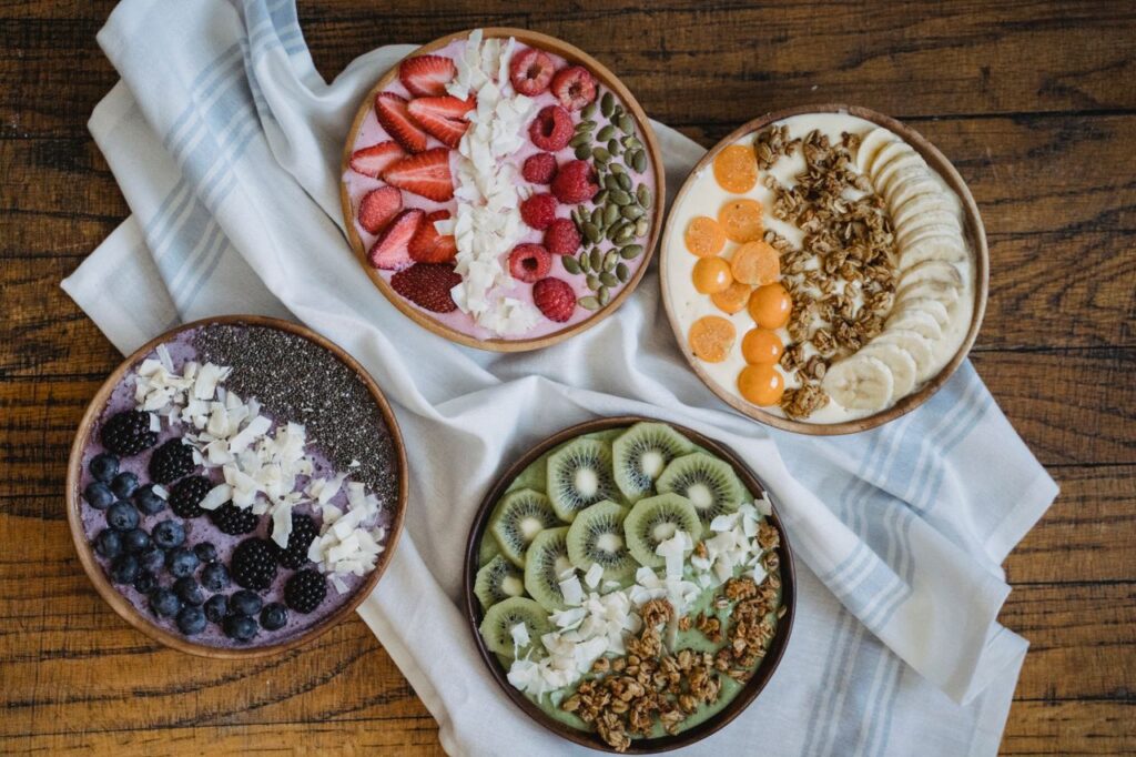 Colorful smoothie bowls topped with fresh fruit, granola, seeds, and other nutritious ingredients for a healthy breakfast.