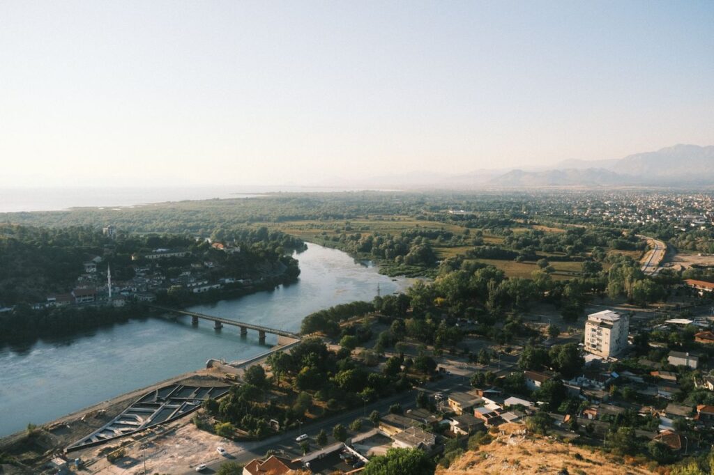 Holiday destinations for every budget featuring a scenic view of Albania's coastline, river and surrounding mountains.